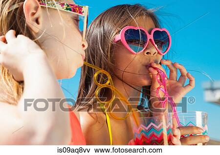 Girls wearing sunglasses drinking through straws View Large Photo Image Stock Photo - Girls wearing sunglasses drinking through straws. Fotosearch