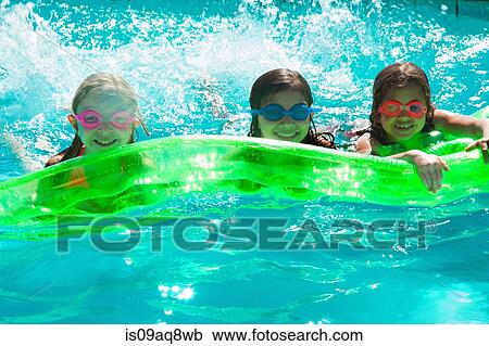 Stock Image - Girls with inflatable toy in swimming pool. Fotosearch