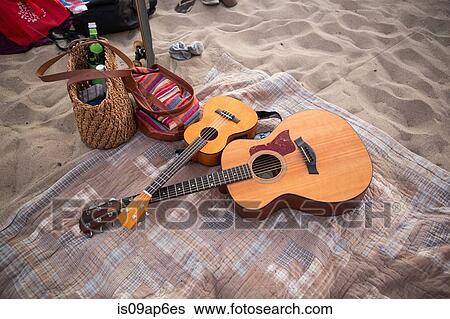 Guitars and bags on picnic blanket on sandy beach View Large Photo Image Stock Photograph - Guitars and bags on picnic blanket on sandy beach. Fotosearch