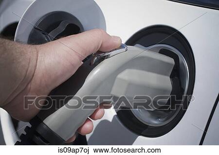 Hand holding electric car charger View Large Photo Image Stock Image - Hand holding electric car charger. Fotosearch