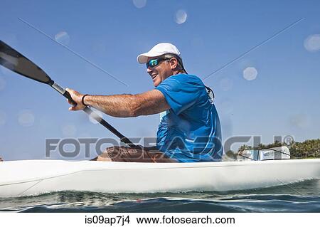 Picture - Kayaker rowing in sea. Fotosearch