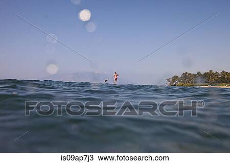 Stock Image - Kayaker rowing in sea. Fotosearch