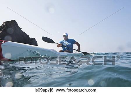 Stock Photograph - Kayaker rowing in sea. Fotosearch