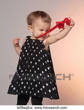 Little girl pulling at her bow View Large Photo Image Stock Photo - Little girl pulling at her bow. Fotosearch