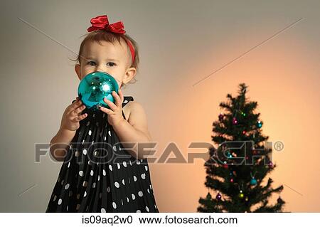 Stock Image - Little girl with christmas bauble. Fotosearch