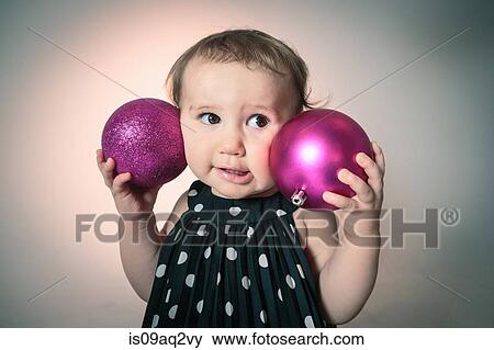 Little girl with pink christmas baubles View Large Photo Image Stock Photo - Little girl with pink christmas baubles. Fotosearch