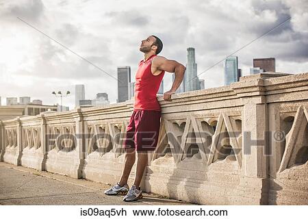 "Male runner leaning back taking a break on bridge, Los Angeles, California, USA" View Large Photo Image Stock Image - "Male runner leaning back taking a break on bridge, Los Angeles, California, USA". Fotosearch