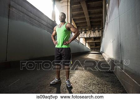 Male runner taking a break under city bridge View Large Photo Image Stock Photography - Male runner taking a break under city bridge. Fotosearch
