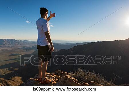 Stock Image - "Male trail runner covering eyes from sun on Pacific Crest Trail, Pine Valley, California, USA". Fotosearch