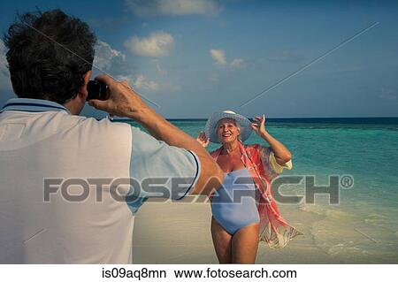 "Man photographing senior woman, Maldives" View Large Photo Image Picture - "Man photographing senior woman, Maldives". Fotosearch