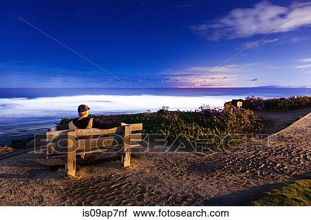 Stock Image - "Man sitting on bench, looking at view, Del Mar, California, USA". Fotosearch