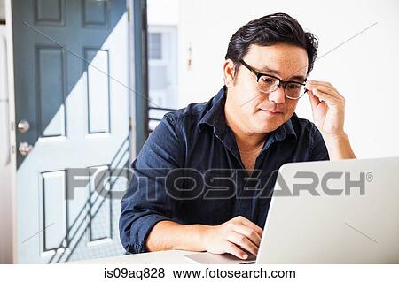 Mature businessman concentrating on laptop in kitchen View Large Photo Image Stock Photo - Mature businessman concentrating on laptop in kitchen. Fotosearch
