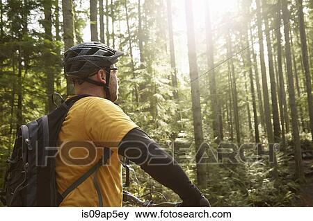 "Mature man riding bike in forest, rear view" View Large Photo Image Stock Photo - "Mature man riding bike in forest, rear view". Fotosearch