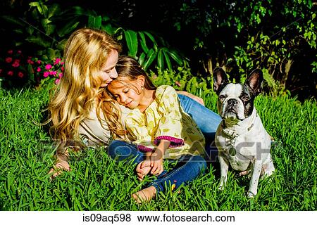 "Mature woman, daughter and dog sitting in garden grass" View Large Photo Image Stock Photo - "Mature woman, daughter and dog sitting in garden grass". Fotosearch