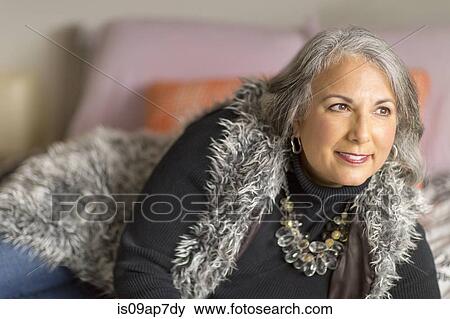 Mature woman relaxing on bed View Large Photo Image Stock Photo - Mature woman relaxing on bed. Fotosearch