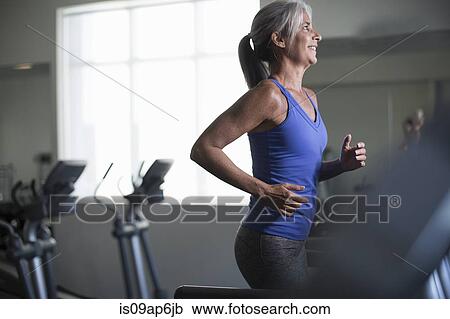 Mature woman running on gym treadmill View Large Photo Image Stock Image - Mature woman running on gym treadmill. Fotosearch