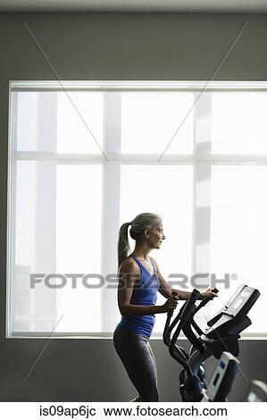 Mature woman using gym step machine View Large Photo Image Stock Image - Mature woman using gym step machine. Fotosearch