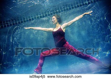 Stock Photography - "Mature woman wearing red yoga pants and vest, in yoga position, underwater view". Fotosearch