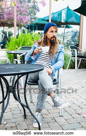 Mid adult man sitting in cafe with coffee View Large Photo Image Stock Photograph - Mid adult man sitting in cafe with coffee. Fotosearch