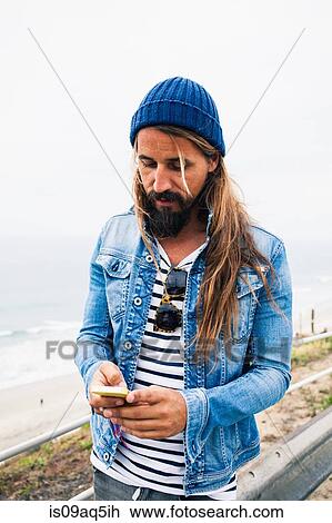 Mid adult man using cell phone View Large Photo Image Stock Image - Mid adult man using cell phone. Fotosearch