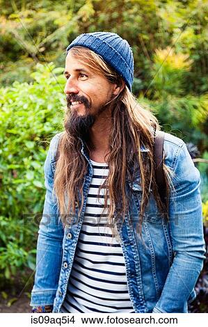 "Mid adult man with long hair, wearing hat" View Large Photo Image Picture - "Mid adult man with long hair, wearing hat". Fotosearch