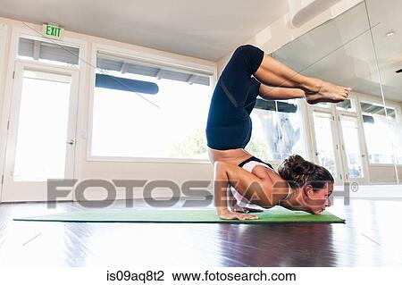 Stock Image - Mid adult woman in yoga position. Fotosearch