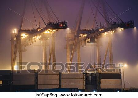 "Misty view of harbor cranes and stacked cargo containers at night, Seattle, Washington, USA" View Large Photo Image Stock Photography - "Misty view of harbor cranes and stacked cargo containers at night, Seattle, Washington, USA". Fotosearch