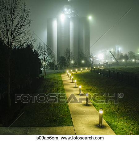 "Misty view of industrial storage tanks and floodlit path at night, Seattle, Washington, USA" View Large Photo Image Picture - "Misty view of industrial storage tanks and floodlit path at night, Seattle, Washington, USA". Fotosearch