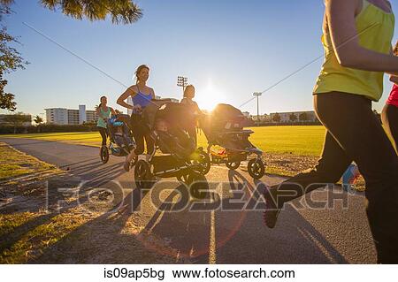 Mothers jogging in park with pushchairs View Large Photo Image Stock Image - Mothers jogging in park with pushchairs. Fotosearch