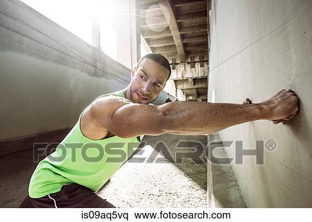 Muscular male runner doing wall push ups under city bridge View Large Photo Image Stock Photography - Muscular male runner doing wall push ups under city bridge. Fotosearch