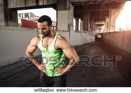 Muscular male runner taking a break under city bridge View Large Photo Image Stock Photograph - Muscular male runner taking a break under city bridge. Fotosearch