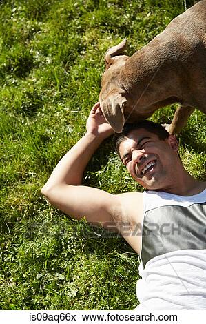 Overhead view of young man playing with dog on grass View Large Photo Image Stock Photo - Overhead view of young man playing with dog on grass. Fotosearch