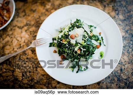 Plate of kale salad and nuts on restaurant table View Large Photo Image Stock Photography - Plate of kale salad and nuts on restaurant table. Fotosearch