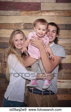 Stock Photo - Portrait of a happy young family. Fotosearch
