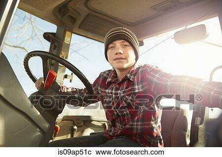 Portrait of boy farmer driving tractor on dairy farm View Large Photo Image Stock Image - Portrait of boy farmer driving tractor on dairy farm. Fotosearch
