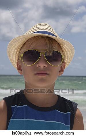 Stock Photo - "Portrait of boy wearing straw hat and sunglasses on beach, Anna Maria Island, Florida, USA". Fotosearch