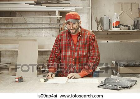Portrait of cabinet maker checking blueprint at workshop bench View Large Photo Image Stock Image - Portrait of cabinet maker checking blueprint at workshop bench. Fotosearch