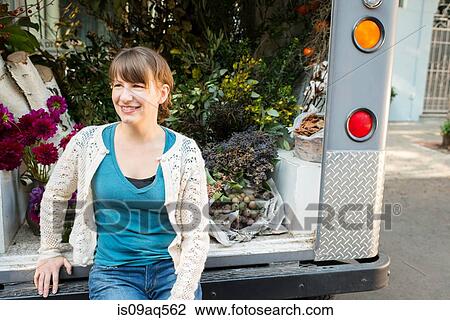 Stock Image - Portrait of florist sitting on back of delivery truck. Fotosearch