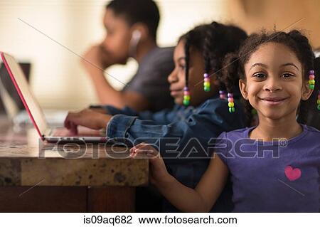 Portrait of girl at dining table and siblings using laptops View Large Photo Image Stock Image - Portrait of girl at dining table and siblings using laptops. Fotosearch