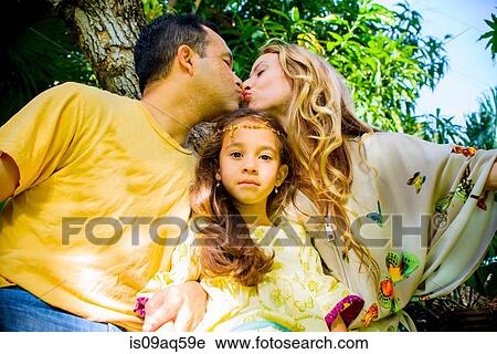 Portrait of girl between affectionate mature parents in garden View Large Photo Image Stock Image - Portrait of girl between affectionate mature parents in garden. Fotosearch