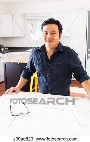 Stock Photo - Portrait of mature man at kitchen table. Fotosearch