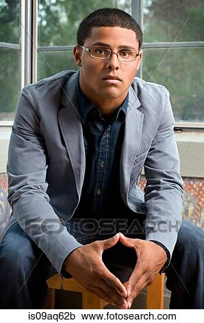 Stock Image - Portrait of mature serious teenage boy in front of window. Fotosearch