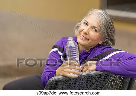Portrait of mature woman holding water bottle View Large Photo Image Stock Photo - Portrait of mature woman holding water bottle. Fotosearch