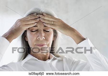 Portrait of mature woman meditating with hands on forehead View Large Photo Image Stock Image - Portrait of mature woman meditating with hands on forehead. Fotosearch