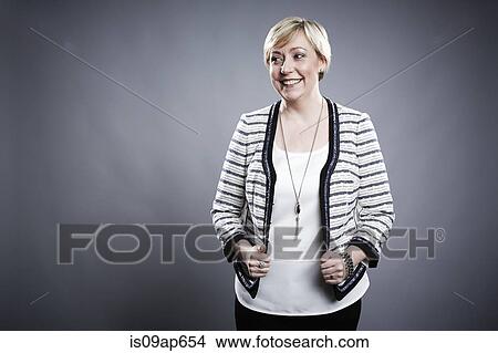 Picture - "Portrait of mature woman, pulling on jacket edges". Fotosearch