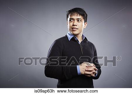 Stock Image - "Portrait of mid adult man, hands clasped". Fotosearch