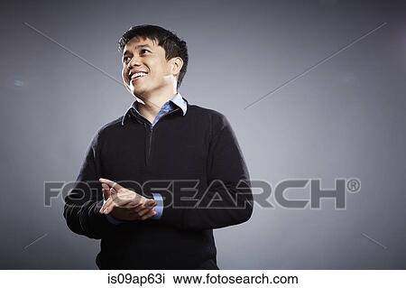 Stock Image - "Portrait of mid adult man, hands together". Fotosearch