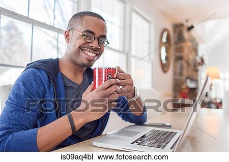 Portrait of mid adult man using laptop at kitchen counter View Large Photo Image Stock Image - Portrait of mid adult man using laptop at kitchen counter. Fotosearch