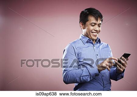 Portrait of mid adult man using smartphone View Large Photo Image Stock Photo - Portrait of mid adult man using smartphone. Fotosearch