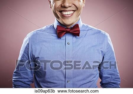 Stock Image - "Portrait of mid adult man wearing red tie, smiling". Fotosearch